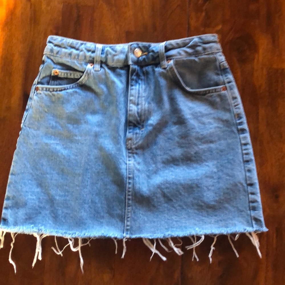 Topshop Size 6, light wash denim mini skirt with frayed edges.